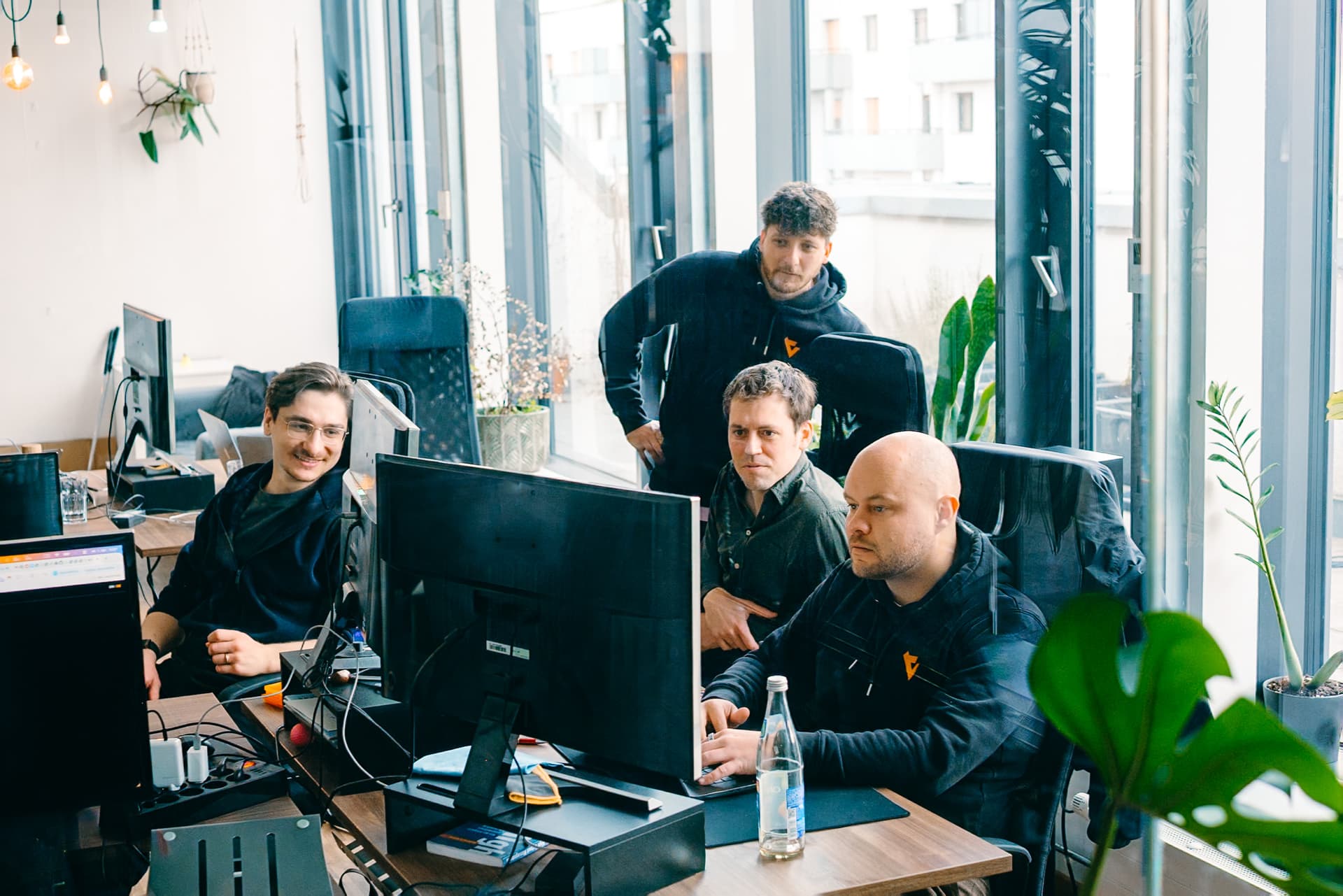 Team vor einem Bildschirm im Besprechungsraum
